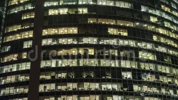 摩天大楼和商务中心的办公室窗户在一个多雾的夜晚时间流逝高度流逝视频的预览图