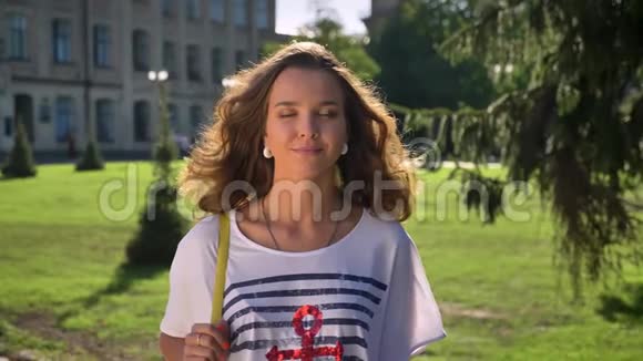 公园里一位年轻的笑着的白种人黑发美女的肖像背景是大学视频的预览图