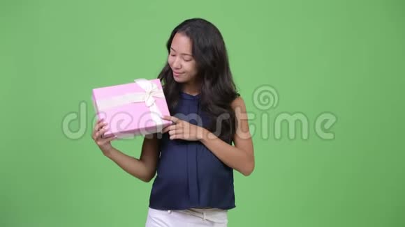 年轻快乐的怀孕多民族女商人手里拿着礼品盒视频的预览图