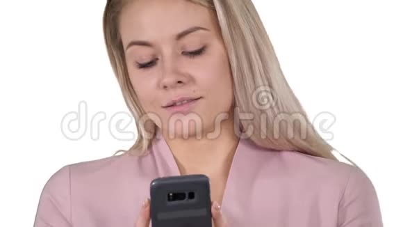 时髦的微笑金发女人使用她的手机微笑当她键入一条短信在白色背景视频的预览图