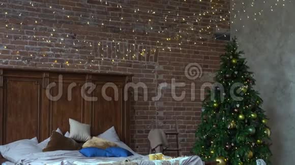 时尚的圣诞节内部卧室有很多灯以装饰圣诞树的阁楼风格舒适的家视频的预览图