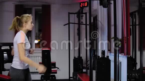 在健身房锻炼时踩板上的漂亮女孩视频的预览图