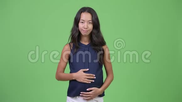 年轻快乐怀孕多民族的女商人嘴唇上戴着手指视频的预览图