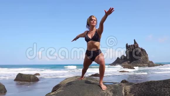 与自然和谐相处的女人站在海边的石头上沉思视频的预览图