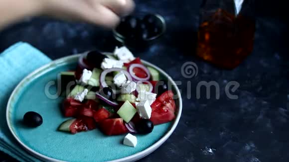 做希腊沙拉在一个绿色的盘子里我们把西红柿黄瓜切片视频的预览图