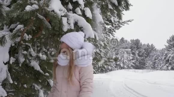 小女孩在冬天的树林里玩得很开心视频的预览图
