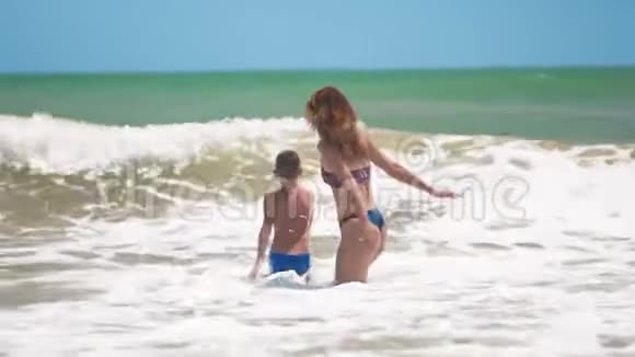 母子二人跳入大海上浪荡重新加入玩得开心视频的预览图
