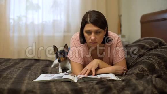 女人看杂志狗躺在她旁边视频的预览图