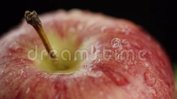 在视频中我们看到一个红苹果水开始从顶部倾泻就像淋浴黑色背景特写视频的预览图