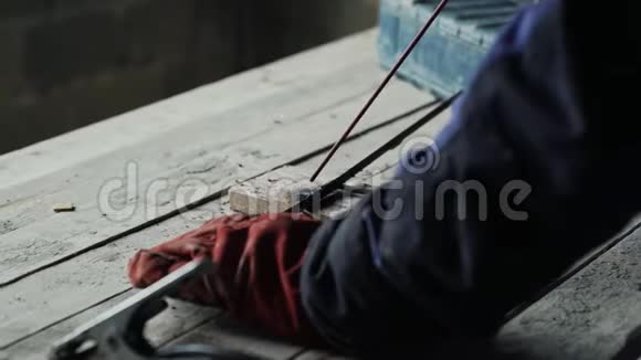封闭式焊机在焊接面罩时焊接两个金属零件穿工作服的工人在室内工作视频的预览图