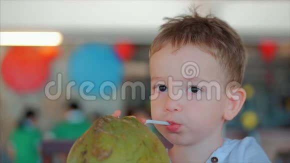 可爱的孩子喝椰子槽一根稻草特写概念孩子快乐童年夏天宝宝假期视频的预览图