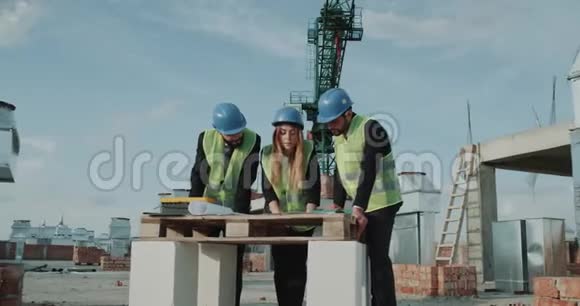 两个穿西装的商人和一个女建筑师分析了一座新建筑的工程视频的预览图