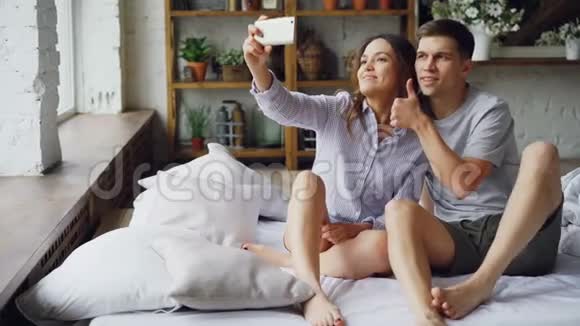 漂亮的亚洲女孩正在和她英俊的高加索男友自拍她拿着智能手机摆姿势和接吻浪漫浪漫视频的预览图