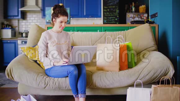 女人坐在沙发上在网上聊天女人在网上购物视频的预览图