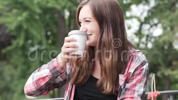 一个女人正在街上的一家咖啡馆里喝咖啡视频的预览图