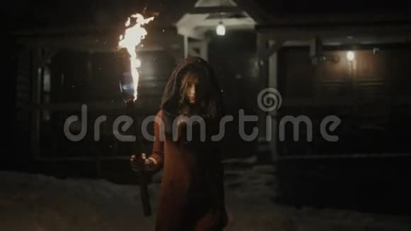 一个年轻神秘女人在黑暗中拿着火炬的肖像视频的预览图