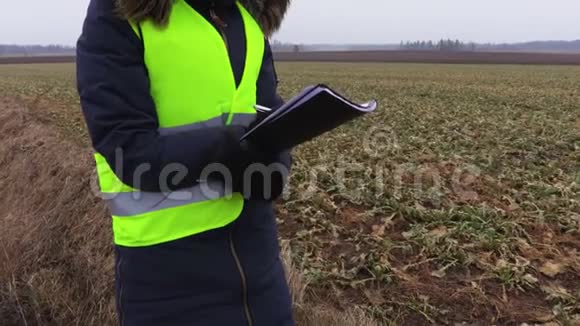 女农民冬天在田野附近写作视频的预览图
