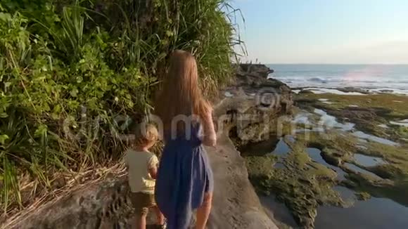 一家人在巴厘岛的塔纳罗特神庙的岩石海岸上行走拍摄了一张照片视频的预览图
