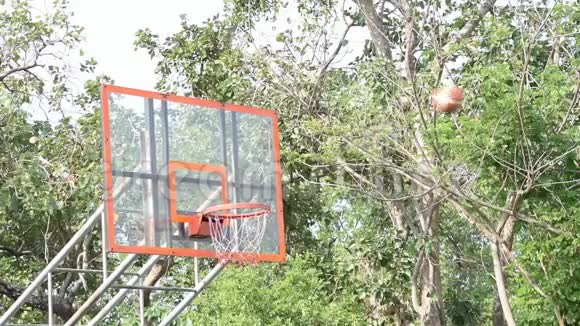 篮球篮筐和网摇球落下背景树在公园里视频的预览图