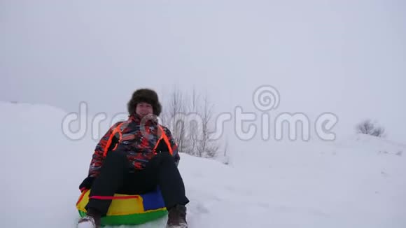 快乐的人从高雪中滑出一个充气的雪管人们在冬天在公园里玩圣诞节视频的预览图