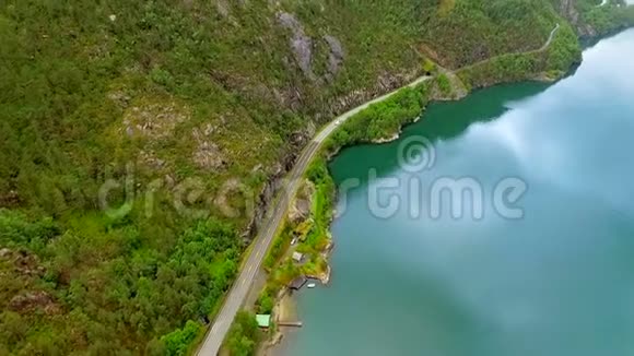 空中观景这辆车沿着河在群山之间的公路上行驶挪威视频的预览图