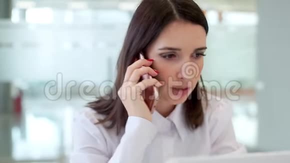 女孩在电话里说话讨论工作问题看着笔记本电脑视频的预览图