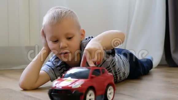 可爱的小男孩在家玩玩具车视频的预览图