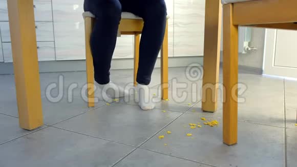 女人把他的脚屑扔到桌子下面厨房地板上的遗落物肮脏的厨房地板视频的预览图
