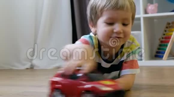 可爱的小男孩在家玩玩具车视频的预览图