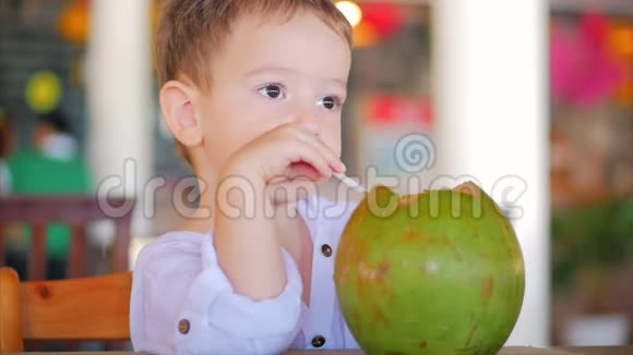 可爱的孩子喝椰子槽吸管近距离概念孩子快乐的童年夏天孩子假期视频的预览图