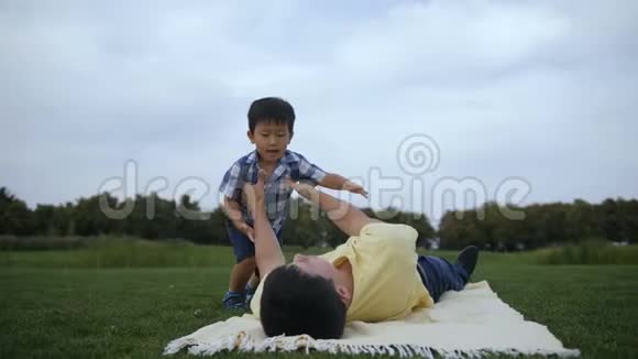 父亲和可爱的亚洲儿子在外面休闲视频的预览图