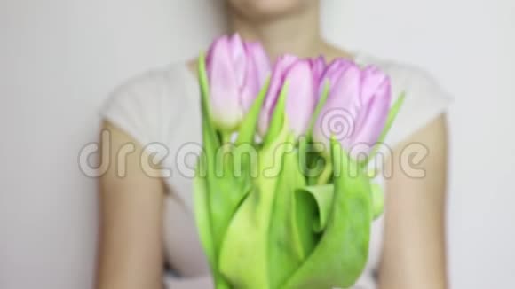 一位面目全非的女士在展示一束春天的鲜花紫丁香郁金香特写3月8日情人节或母亲节视频的预览图