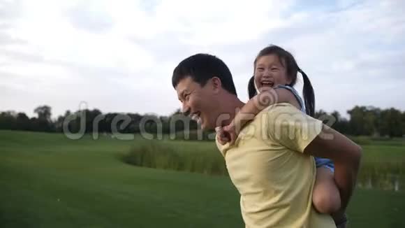 可爱的亚洲女儿和她爸爸骑着驮子视频的预览图
