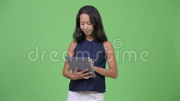 年轻快乐怀孕的多民族女商人在使用数字平板电脑时的思考视频的预览图
