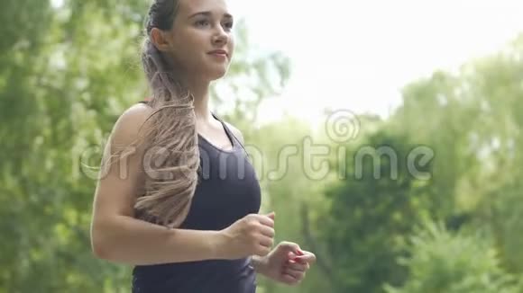 一位留着长发的女跑步者在户外公园跑步漂亮的女士慢跑视频的预览图