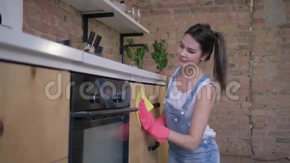 幸福的家庭主妇戴着橡胶手套的快乐管家妇女的肖像在烹饪和家庭的全面清洁中视频的预览图