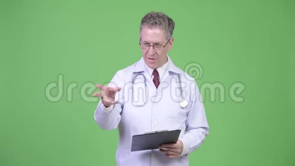 成人医生在剪贴板上阅读时解释的肖像视频的预览图