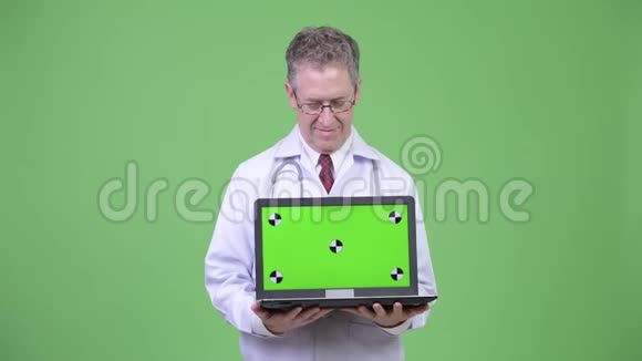 快乐成熟男医生的画像展示和看手提电脑视频的预览图