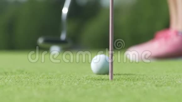 高尔夫球球打洞日落时在高尔夫球场打球的球员是美丽的自然用杆旗放绿色视频的预览图