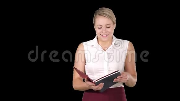 女人拿着打开书或笔记本大声朗读一些东西阿尔法频道视频的预览图