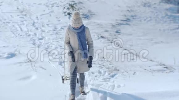 冻僵的滑稽女人拖着雪橇在户外视频的预览图