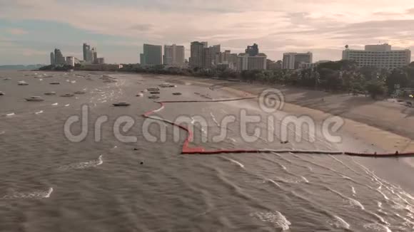 帕塔亚海滩的4k无人机空中飞行清晨日出城市景观天际线在海滩海浪快艇上视频的预览图
