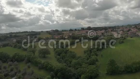 从空中俯瞰意大利丘陵之间的丘陵森林和绿色草地天空壮观视频的预览图