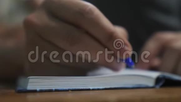 人在笔记本上写字男人手写记事本概念商业教育男人的生活方式会引起注意视频的预览图