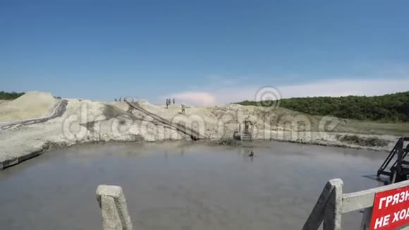 人滑到泥里肮脏的高加索人在舒戈泥火山口游泳视频的预览图