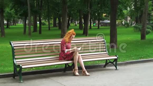 红头发女孩在公园看书视频的预览图