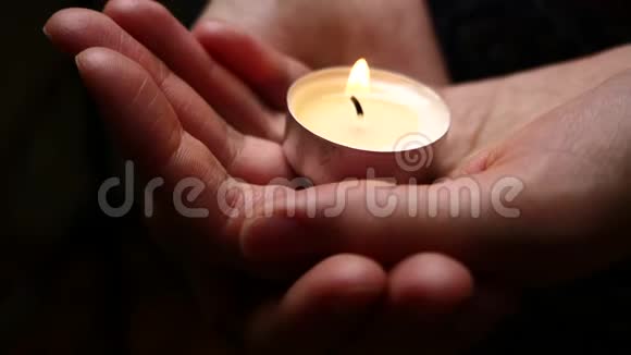 手里拿着蜡烛女性手中蜡烛照明背景仁慈的背景悲伤的概念纪念背景视频的预览图