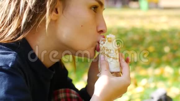 年轻的有着可怕的臀部的时髦女孩吃烤串女孩在公园里吃快餐晴天视频的预览图