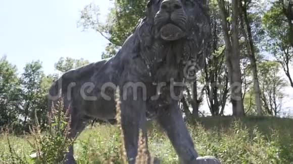 金属狮子雕像夏天后面的树视频的预览图