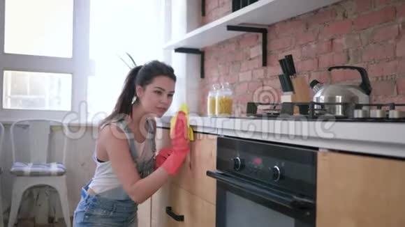 在厨房和家务的全面清洁过程中戴橡胶手套的幸福家庭主妇女孩的肖像视频的预览图
